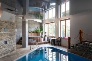 a pool in a hotel room with a swimming pool at Apartament Leśny z kominkiem - Viva Pod Giewontem Apartamenty in Zakopane