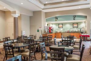a restaurant with tables and chairs and a kitchen at Lake Buenavista Apartments close to Disney in Orlando