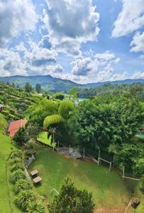 - une vue aérienne sur un parc avec des arbres et des montagnes dans l'établissement Hermosa casa de campo en GUATAPÉ, à Guatapé