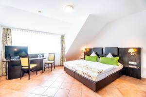 a bedroom with a bed and a desk and a television at My Airport Hotel STUTTGART-AIRPORT-MESSE in Leinfelden-Echterdingen +30 photos