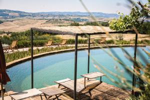 una piscina con una mesa y dos sillas junto a ella en A440 in Tuscany, en Pienza