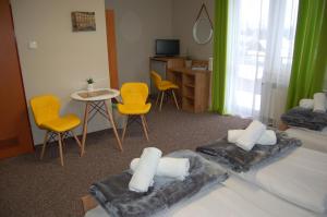 a room with two beds and a table and chairs at Leśne Zacisze in Weremień