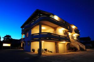 a house with lights on the side of it at night at Apartments Ka - Ro in Bibinje