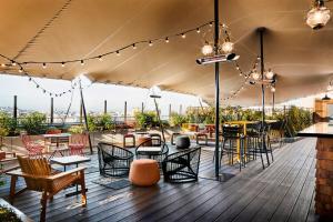 d'un toit-terrasse avec des tables, des chaises et des lumières. dans l'établissement Generator Paris, à Paris