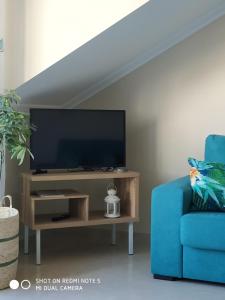 sala de estar con TV y silla azul en Anamari's en Portonovo