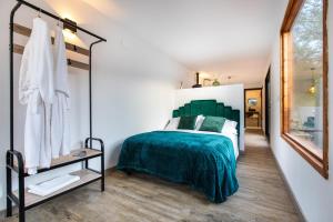 a bedroom with a green bed and a mirror at Mini Rural in Canyelles