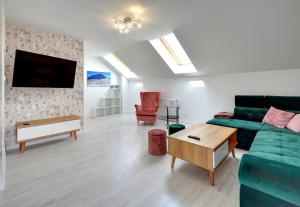 a living room with a green couch and a table at Apartamenty EverySky - Wilcza 3F-2 in Karpacz
