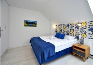 a bedroom with a bed with a blue and white sheets at Apartamenty EverySky - Wilcza 3F-2 in Karpacz