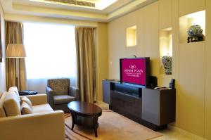 كراون بلازا مركز مدينة قوانغتشو في قوانغتشو: غرفة معيشة مع تلفزيون بشاشة مسطحة في غرفة فندق