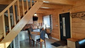 a kitchen with a table and a staircase in a cabin at Domek do wynajęcia - Siedlisko przy lesie in Rząśnik