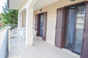 balcón con puerta y mesa con sillas en Homiday - Micaene, en Pineto
