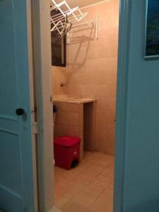 uma casa de banho com um WC vermelho e um lavatório. em Acogedor apartamento a 15 metros del mar em Santa Marta