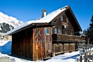 a wooden cabin with snow on the roof at Ruphäusl in Ramsau am Dachstein