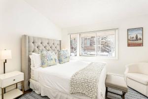 a white bedroom with a large bed and a window at 700 Monarch 301 in Aspen