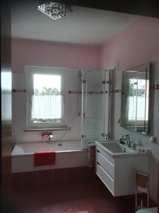 baño con bañera, lavabo y ventana en Wendler`s Haus en Meuselwitz