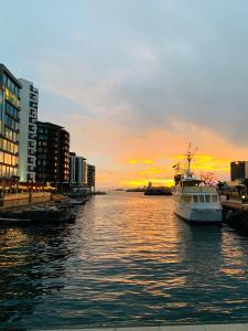 a boat in the water with a sunset in the background at Room Available at City in Oslo