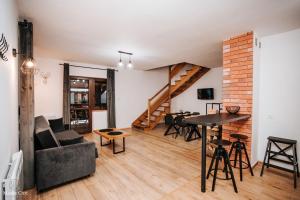 a living room with a couch and a table at Chaty Gajowego w Bieszczadach z basenem 517-665-624 in Bukowiec