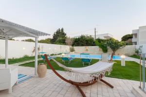 un'amaca su un patio accanto alla piscina di B&B Villa Ginevra a Otranto