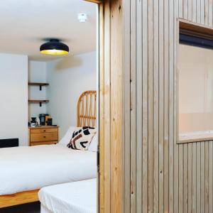 a bedroom with two beds and a wooden wall at CoalShed in Bristol