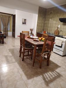 eine Küche mit einem Holztisch und Stühlen im Zimmer in der Unterkunft El Descanso in Lobos