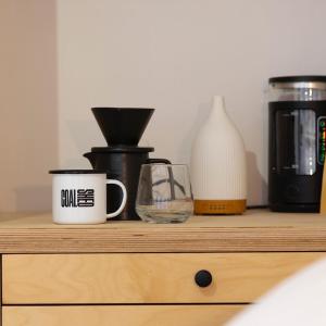 a wooden shelf with cups and a coffee maker on it at CoalShed in Bristol