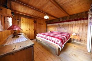 ein Schlafzimmer mit einem Bett in einem Holzzimmer in der Unterkunft Baita Medil in Predazzo