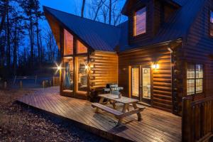 Cabaña de madera con mesa de picnic en la cubierta en Kozy Bear Kabin en Sevierville