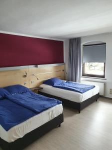 a hotel room with two beds and a window at Pension Stettiner Hof in Eggesin