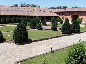 eine Reihe von Bäumen in einem Innenhof mit einem Gebäude in der Unterkunft La Foresteria dei Baldi in Pavia