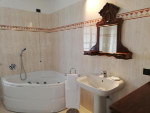 La salle de bains blanche est pourvue d'une baignoire et d'un lavabo. dans l'établissement La Foresteria dei Baldi, à Pavia