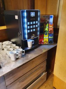 a counter with coffee cups and a microwave on it at Pension Stettiner Hof in Eggesin