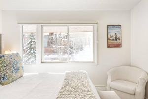 una camera da letto con un letto, una sedia e una finestra di 700 Monarch 301 ad Aspen
