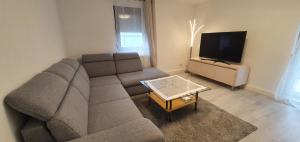 uma sala de estar com um sofá e uma televisão de ecrã plano em Outletcity Ferienwohnung - Apartment 4 em Metzingen