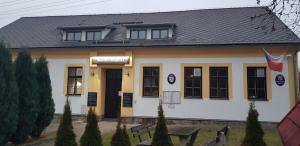 a building with a flag in front of it at Račínská hospůdka in Velká Losenice