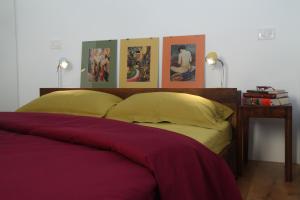 a bed with yellow pillows and paintings on the wall at Apartments Lom in Most na Soči