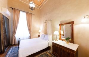 a bedroom with a white bed and a mirror at Nafsimedon Hotel in Nafplio
