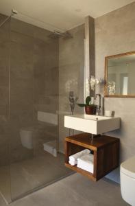een badkamer met een wastafel, een toilet en een spiegel bij Apartments Lom in Most na Soči
