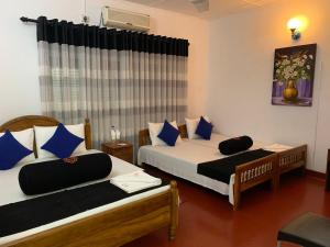 una camera da letto con due letti con cuscini blu di Sobha Holiday Home a Anuradhapura