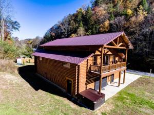 Cabaña de madera con porche y techo en Black Bear Lodge en Pigeon Forge