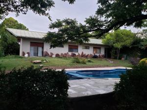 una casa con piscina frente a ella en La MARGARITA en San Rafael