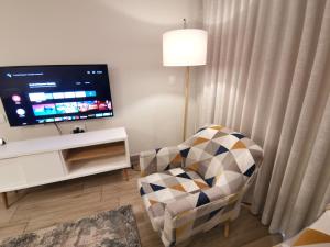 プレトリアにあるRegency Apartment Hotel Menlynのリビングルーム(椅子、薄型テレビ付)
