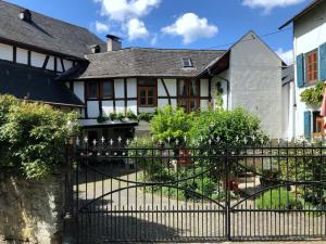 a gate in front of a white and black house at Gut Bunt Ferienhaus in Runkel