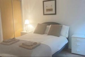 a bedroom with a white bed with two towels on it at Oswald Apartment - Glasgow City Centre in Glasgow