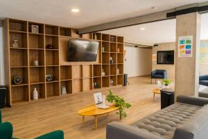 uma sala de estar com um sofá e uma televisão em +MS +Loft Coworking +Vigilancia 24hrs +Internet y Amenities 408 em Laborcillas