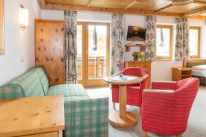 salon z kanapą, krzesłami i stołem w obiekcie Landhotel Tirolerhof - Wildschönau - PREMIUM Card im Sommer w mieście Oberau