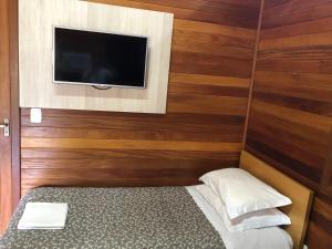 Un dormitorio con una cama y un televisor de pantalla plana. en Chalés De Luxe Gramado, en Gramado 31 fotos más