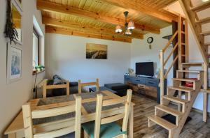 a dining room and living room with a wooden ceiling at Bieszczadzki Jeleń in Ustrzyki Dolne