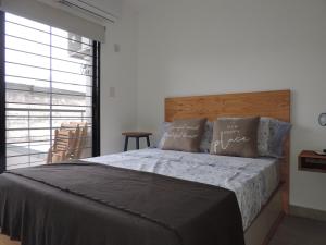 - une chambre avec un grand lit et une tête de lit en bois dans l'établissement Departamento Jujuy, à Rosario