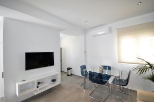 a living room with a glass table and a television at Apartamento La Ola in Conil de la Frontera