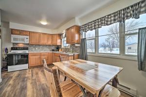a kitchen with a wooden table and a large window at Cozy Houghton Lake Heights Cottage with Private Yard in Houghton Lake